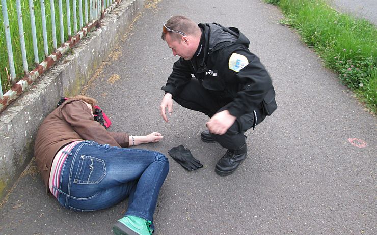 Strážník pomáhá nemocné ženě, která ležela na chodníku. Foto: MP Chomutov