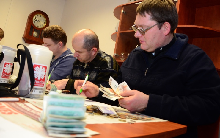 Zástupci charity a města počítají peníze z kasiček. Foto: Město Chomutov 
