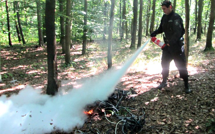 Strážník hasí oheň hasicím přístrojem ze služebního auta. Foto: Měp Chomutov Strážník hasí oheň hasicím přístrojem ze služebního auta. Foto: Měp Chomutov