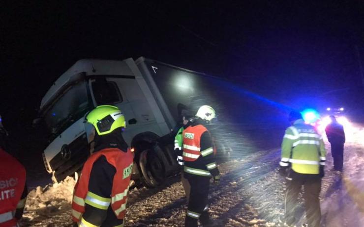 AKTUÁLNĚ: Kamion plný minerálek skončil ve sněhu na boku, probíhá náročné vyprošťování