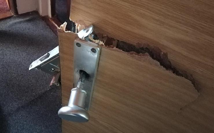 FOTO: Agresivní opilec se dobýval k ženě do bytu, dveře nakonec pokořil 