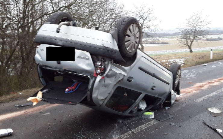 FOTO: Hasiči zveřejnili snímky z ranní nehody u Krabčic. Auto skončilo na střeše, dva lidé se zranili