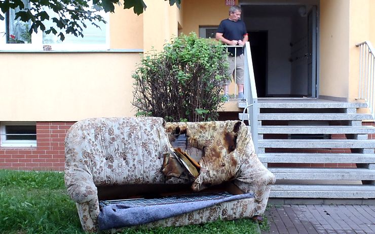 Ohořelou pohovku vynesli před dům. Hasiči byt a chodbu odvětrali. Foto: HZS Ústeckého kraje 
