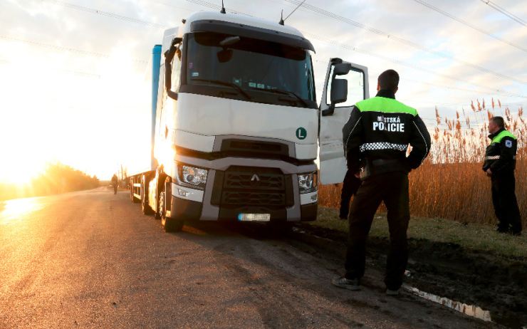 Řidiči kamionů stojí u benzínky v křižovatce, na trávě a někdy i v protisměru