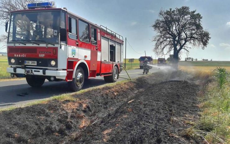 Podél silnice na Žatecku chytila tráva, hasiči likvidovali dvě ohniska požáru