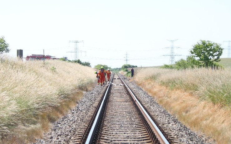 U železniční trati hořel travní porost a keře, hasiči museli natáhnout přes 200 metrů hadic