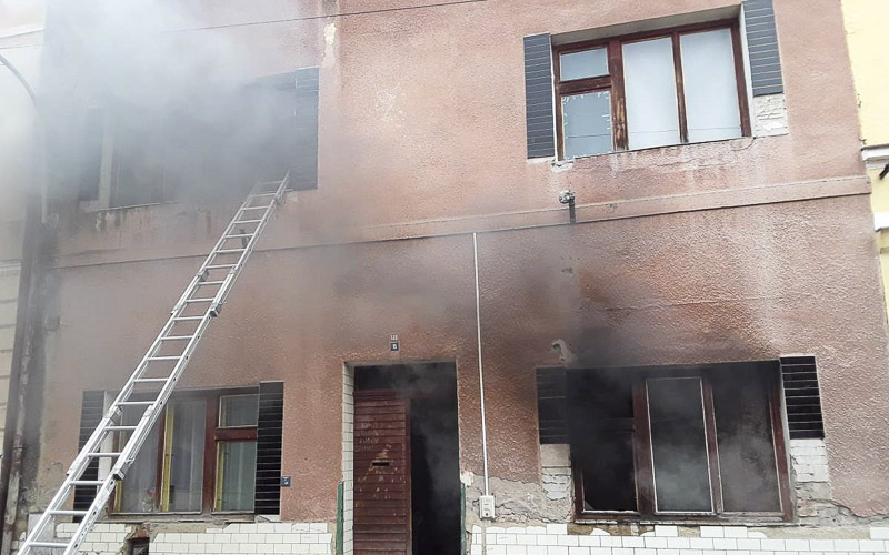 Hasiči pomocí žebříku zachránili člověka z hořícího domu, přiotrávil se kouřem