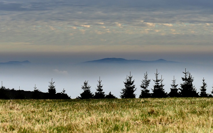 Pohled z Krušných hor do údolí. Vykukují kopce Českého středohoří. Foto: O. Hájek