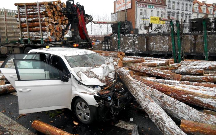 Vážná nehoda na mostě: Návěs s kládami se převrátil na osobní auto