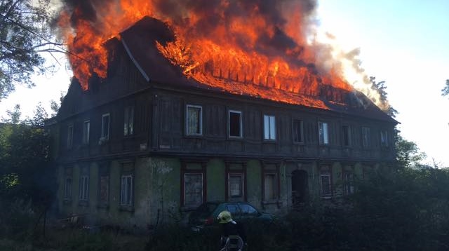 Hasiči bojují s požárem domu. Plameny pohltily celou střechu