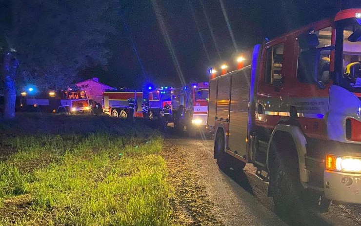 OBRAZEM: Traktor úplně zničil požár, chytl od něj i plášť budovy. S plameny bojovalo šest jednotek hasičů