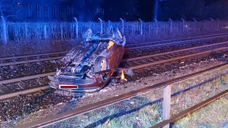 Aktualizujeme! Řidič se svým vozem skončil na střeše a na kolejích, byl opilý. Naštěstí zrovna nejel vlak