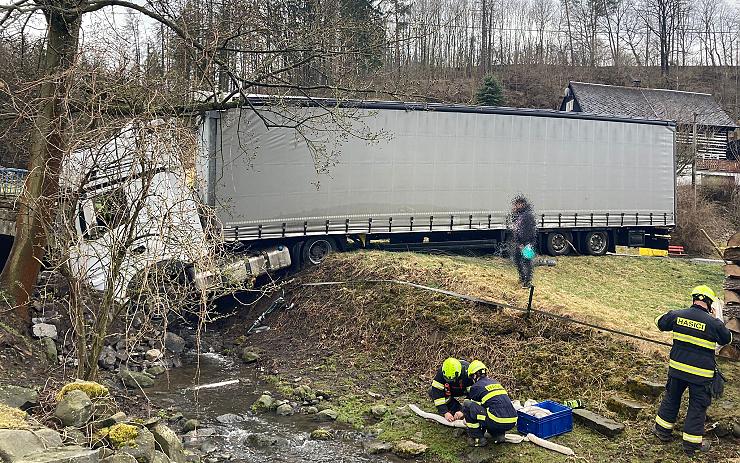 OBRAZEM: Kamion na Děčínsku skončil předními koly v potoce, hasiči raději postavili norné stěny